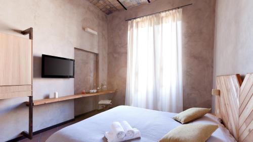 罗马Folia的一间卧室配有一张床,上面有两条毛巾
