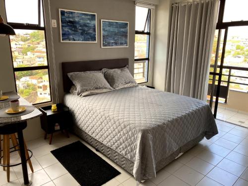 卡尚布Apartamento Studio - Novíssimo e Aconchegante em Caxambu MG的一间卧室设有一张床和一些窗户。