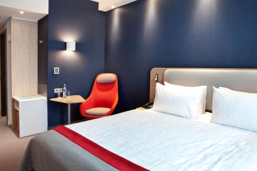 奥伯豪森Holiday Inn Express Oberhausen, an IHG Hotel的酒店客房,配有一张床和一张红色椅子