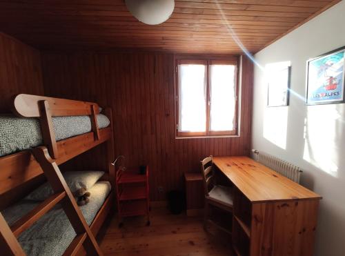 莱德萨阿尔卑斯Panorama 360°的客房设有书桌、双层床和桌子。