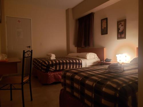 巴伦西亚Hotel La Pequena Valencia的酒店客房,配有两张床和椅子