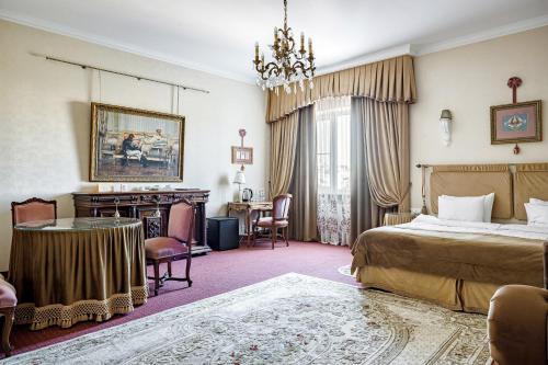 克拉斯诺达尔布里斯托尔酒店的卧室配有一张床和一张桌子及椅子