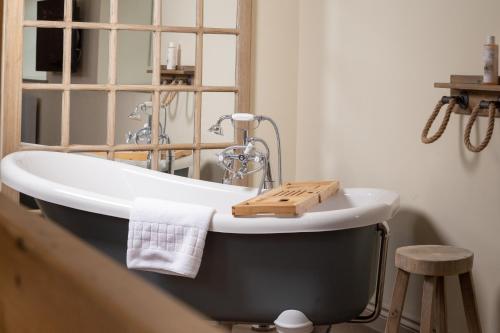 利德福德Castle Inn的浴室内装有木制托盘的浴缸