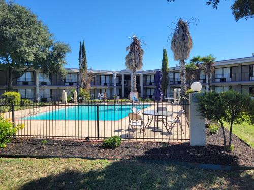 圣安东尼奥Knights Inn San Antonio near Frost Bank Center的建筑前带游泳池的围栏