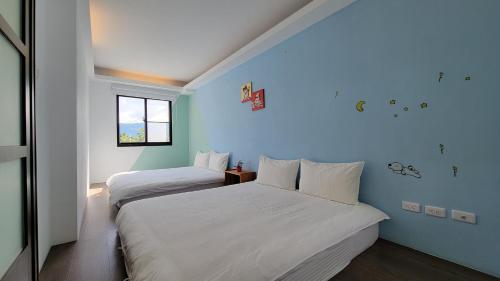 关山镇若家民宿  的蓝色墙壁客房的两张床