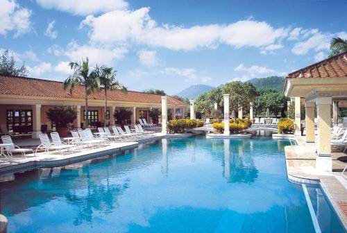 澳门鹭环海天度假酒店的一个带躺椅的游泳池,一个度假村