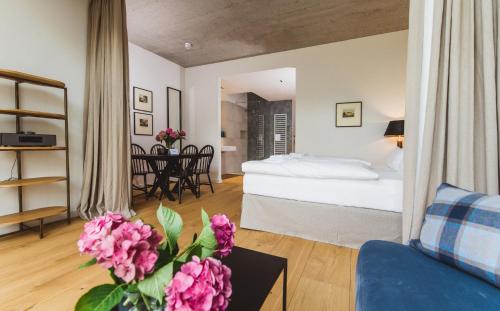 达普Gut Damp Ferien Lofts的客厅配有床和鲜花桌
