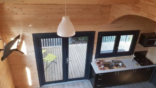 圣让-德蒙Camping Le Logis 3 étoiles的厨房设有2扇窗户和吊灯