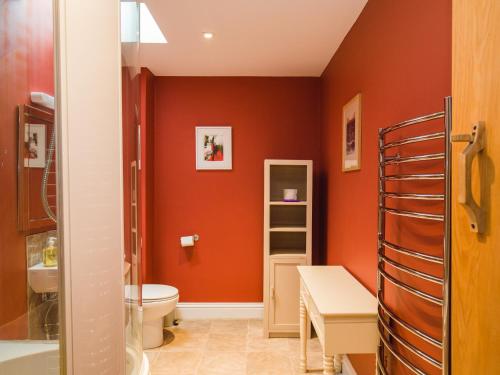 切尔滕纳姆Tom's Barn的浴室设有橙色的墙壁、卫生间和水槽。