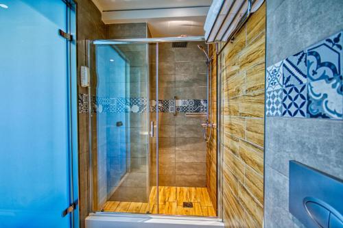 罗德镇岛屿精品酒店的浴室里设有玻璃门淋浴