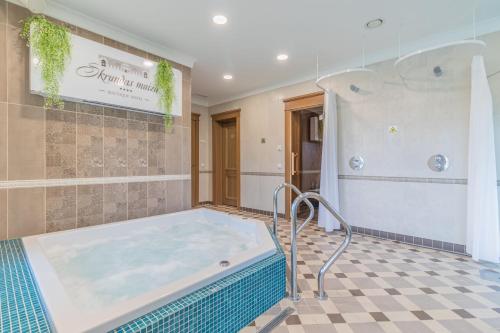 斯克伦达斯库伦达庄园旅馆的浴室设有热水浴缸,铺有瓷砖地板。