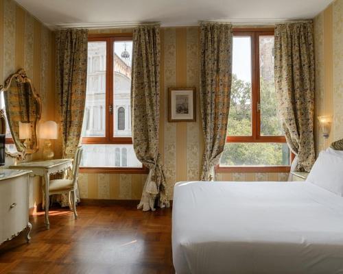 威尼斯Hotel San Zaccaria的一间卧室配有一张床、一张书桌和一个窗户。