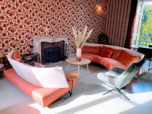 La CelleChâteau de la Combe的客厅配有红色的沙发和椅子