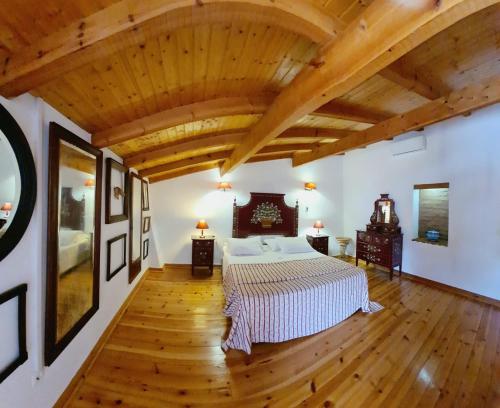 Brotas卡萨斯罗马里亚旅馆的一间卧室设有一张大床和木制天花板。