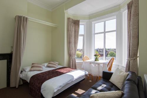 都柏林格伦考特公寓的一间卧室配有一张床、一张沙发和一个窗口