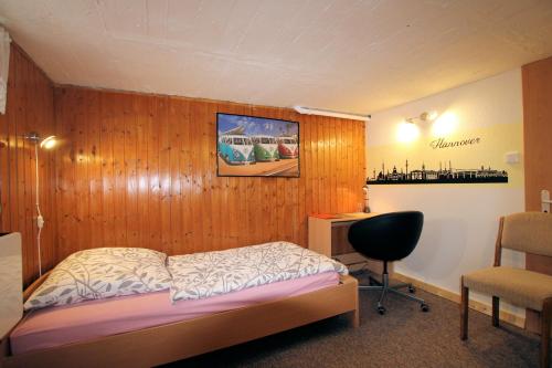 汉诺威ABT - Private Room for 1的一间卧室设有木墙、一张床和一张书桌