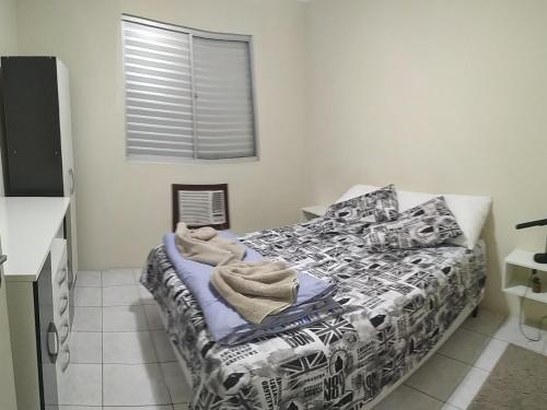 佩洛塔斯Apto 2 quartos, cond fechado, com vaga, quarto andar的一间卧室配有一张带黑白色棉被的床