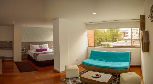 波哥大Hotel Confort 80 Zona Rosa的酒店客房,配有一张床和一张蓝色椅子