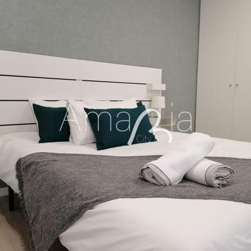 阿威罗AmaRiaCity AL的卧室配有带枕头的大型白色床
