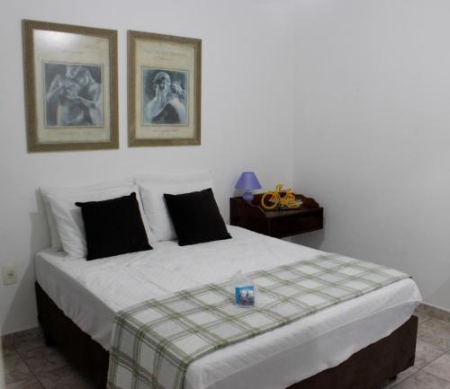 桑托斯Rota 013 - Santos Canal 4的卧室配有一张大床,墙上挂有两张照片