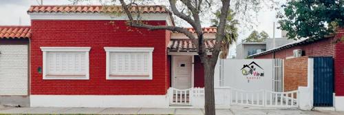 迈普OliWine hostel的前面有白色围栏的红砖房子