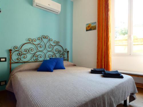 圣雷莫Casa Matuzia的一间卧室配有一张带两个蓝色枕头的床