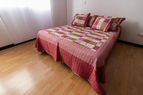 马尼萨莱斯Milán, Acogedor apto en Zona Rosa con Balcón的一张床上的被子和枕头