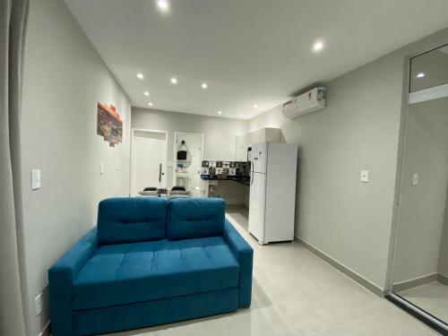 里约热内卢Waikiki Apartament Ipanema的客厅配有蓝色沙发,设有冰箱