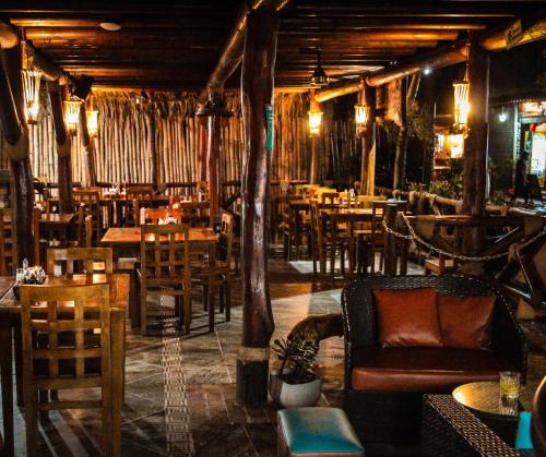 帕洛米诺Primaluna Beach Hostel的餐厅设有桌椅和沙发。