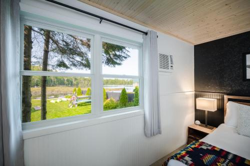 普莱西德湖Placid Bay Hotel的卧室设有窗户,享有庭院的景色