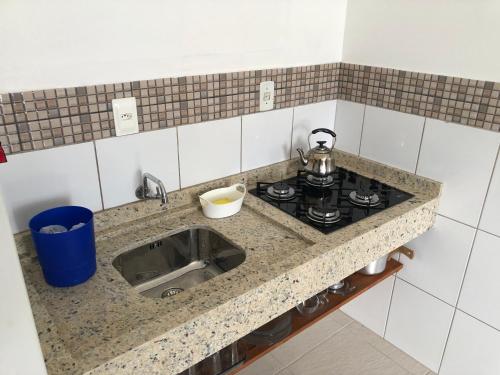 帕罗卡Apartamento Ilha do Coral的厨房柜台配有炉灶和水槽