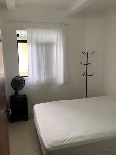 帕罗卡Apartamento Ilha do Coral的白色的卧室设有床和窗户