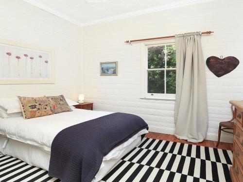 ExeterPoppy Cottage的一间卧室设有一张床和一个窗口