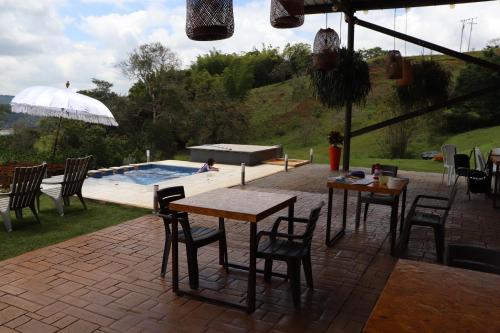 卡利马ADAMA BIOHOTEL的一个带桌椅的庭院和一个游泳池