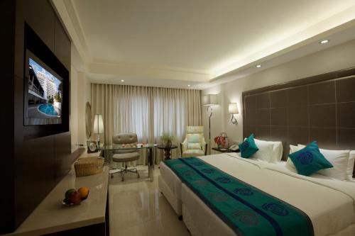 钦奈萨维拉酒店的酒店客房设有一张大床和一张书桌。