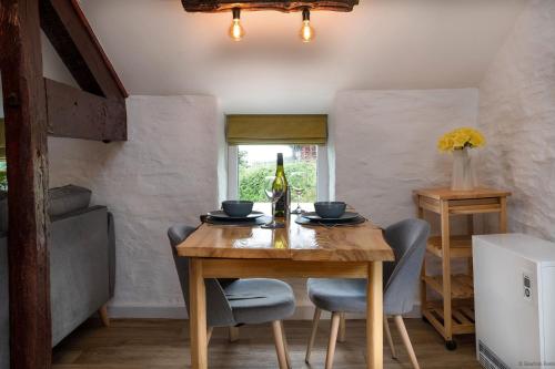 Bryn-crugThe Granary的一间带木桌和一瓶葡萄酒的用餐室