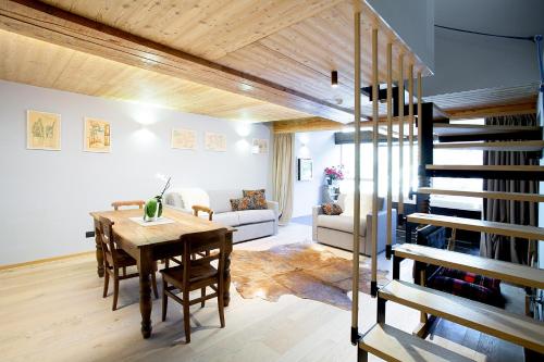 布勒伊-切尔维尼亚Aux Pieds du Roi - Suite & Spa的客厅设有木桌和螺旋楼梯。