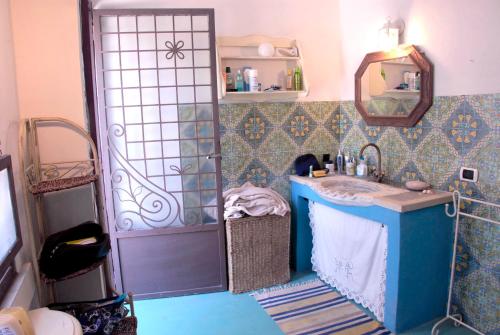 赛拉诺Casa al Sole Ponente的浴室配有盥洗盆和带镜子的淋浴