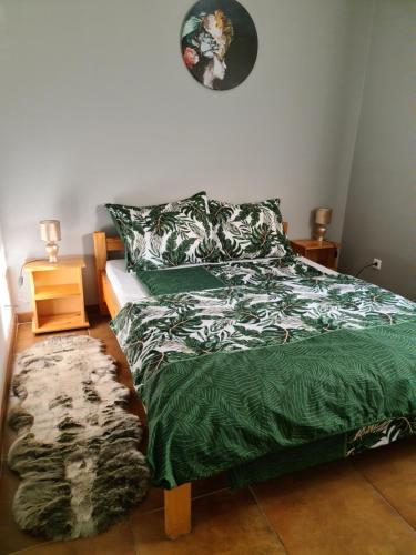 莫劳豪洛姆Amina Apartman的一间卧室配有一张带绿色棉被的床