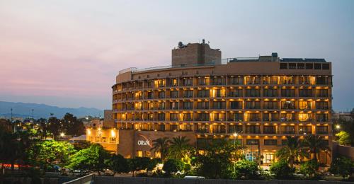 亚喀巴Oryx Hotel Aqaba的城市的一座建筑,晚上有灯光