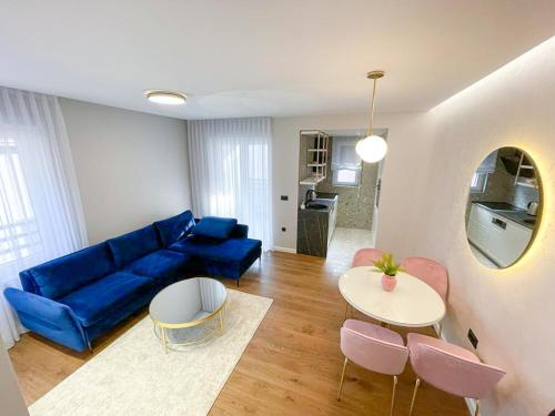 巴尼亚卢卡Premium Apartmani Banja Luka的客厅配有蓝色的沙发和桌子