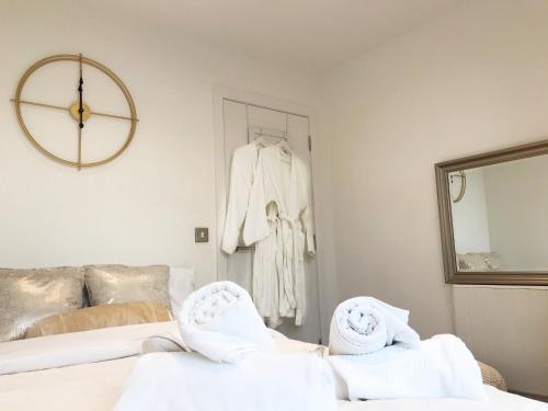 伯恩茅斯* PANORAMIC PENTHOUSE WITH SEA & CITY VIEWS的一间带镜子的卧室和一张带毛巾的床