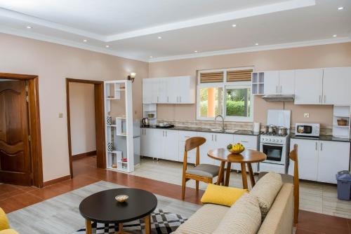 基加利IGITEGO APARTHOTEL LTD的厨房以及带沙发和桌子的客厅。