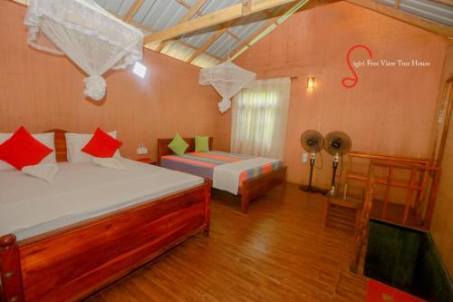 锡吉里亚Sigiri Free View Tree House & Villa的一间卧室配有一张床和一张带风扇的桌子。