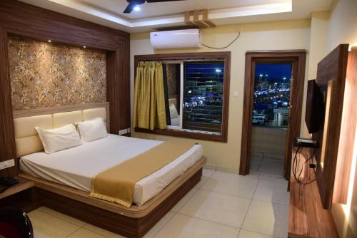 普里Hotel Guru Estate的一间卧室设有一张大床和一个窗户。