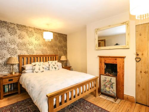 艾尔舍姆Valentine Cottage的一间卧室配有一张床和镜子