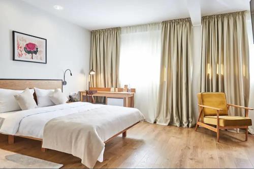 第比利斯Urban Park Hotels的卧室配有床、椅子和窗户。