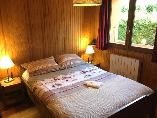 阿尔利河畔普拉兹Le Nantoran的一间卧室配有一张带两盏灯的床和一扇窗户。