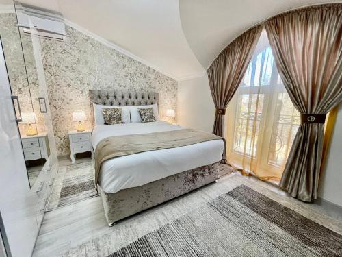 基希讷乌Premier City Apart Hotel Chisinau的一间卧室设有一张床和一个大窗户