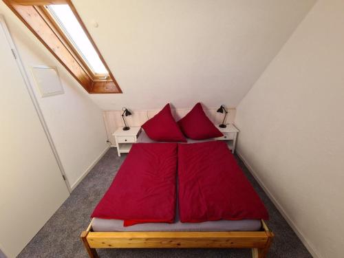阿尔戈伊地区伊斯尼Ferienwohnung-Rotmoosblick-direkt-am-Rande-unberuehrter-Natur的小房间一张带红色枕头的床